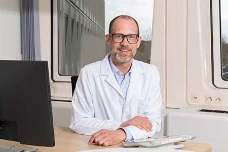 audiologist sitting at desk smiling