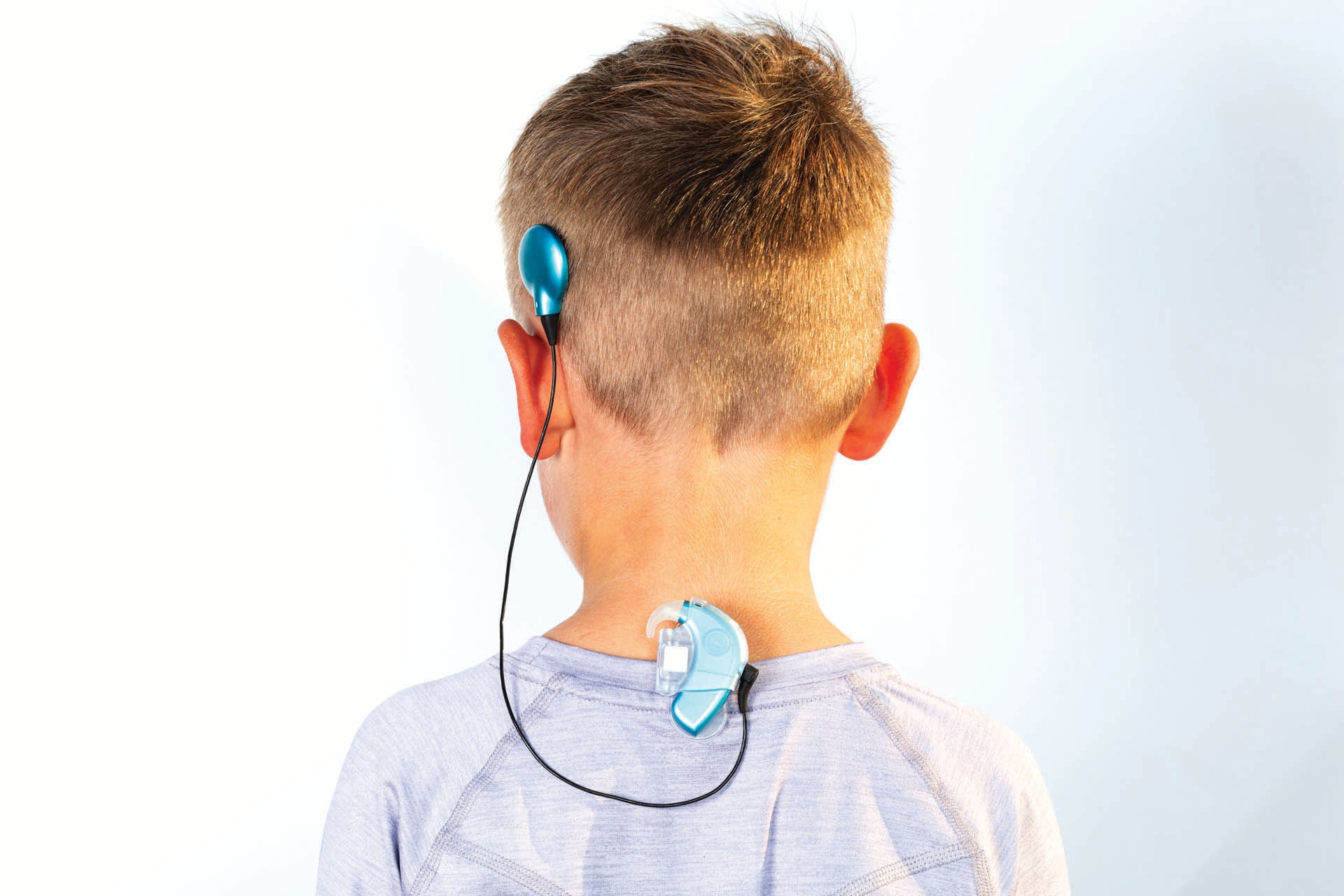 a child cochlear implant recipient with marvel ci clipped back of the shirt