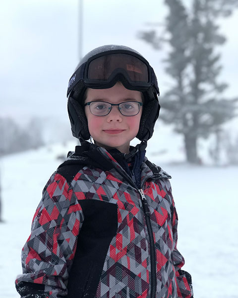 Jacob Schneider, a child with bilateral cochlear implants is outside in the snow
