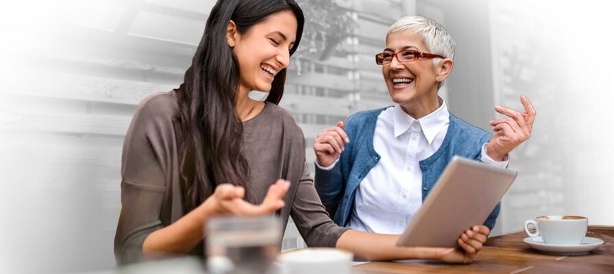two people looking at a tablet and laughing