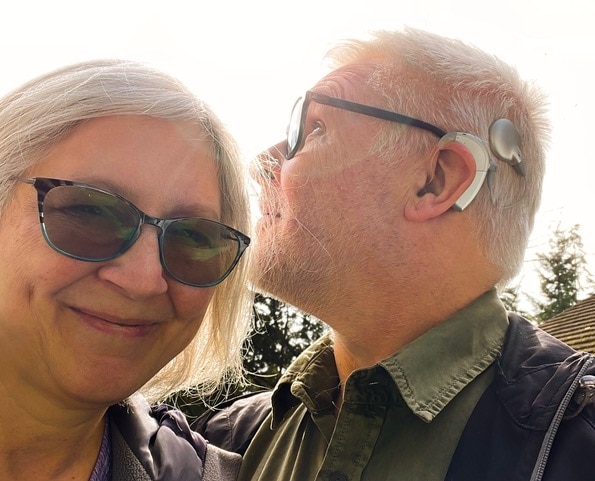blog author Vince Werner next to his wife, showing his AB Cochlear Implant