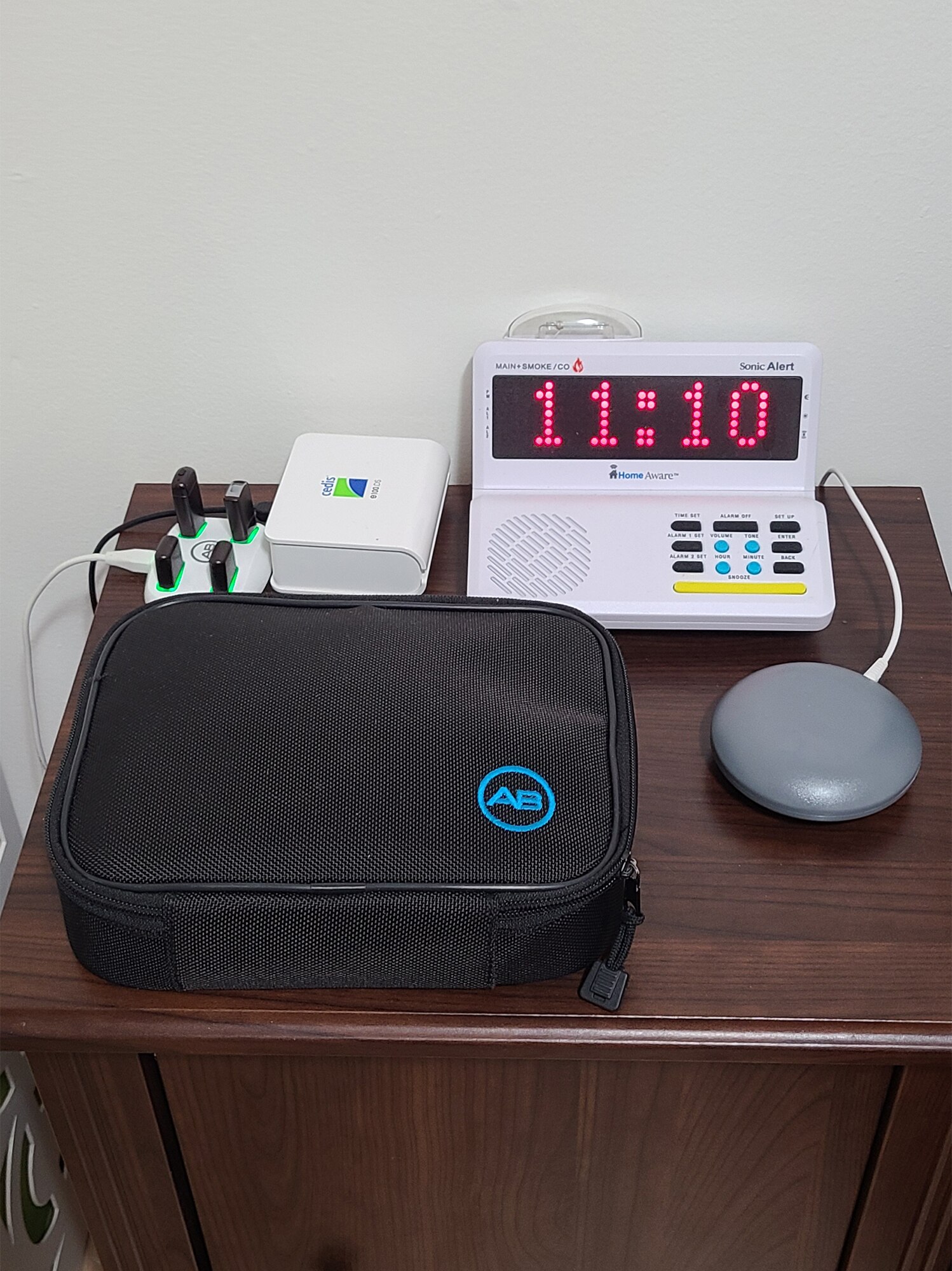 Shobana's nightstand with a night shaker alarm clock, an essential part of her daily routine living with cochlear implants.