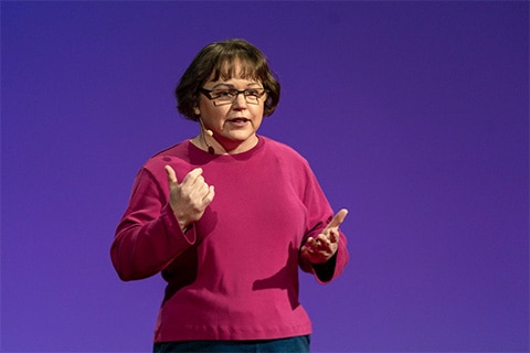 A woman with a cochlear implant gives a lecture