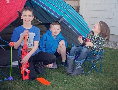 The children of a mother with a cochlear implant pose for a picture