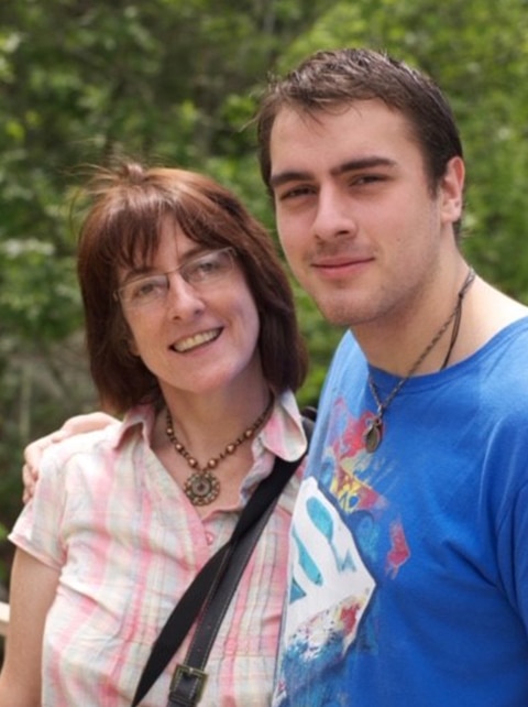 Adult with a cochlear implant takes a picture with his mother.