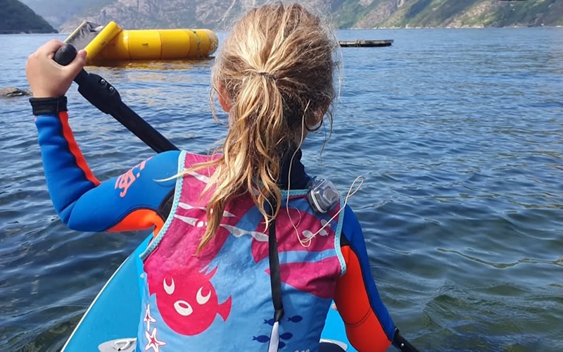 A smiling family sit around a dinner table, posing for a family photo