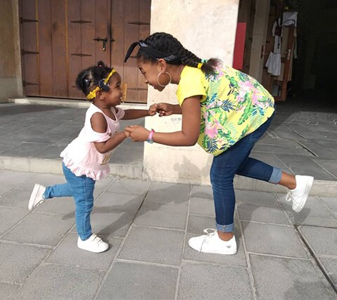 Child with a cochlear implant plays with her sister