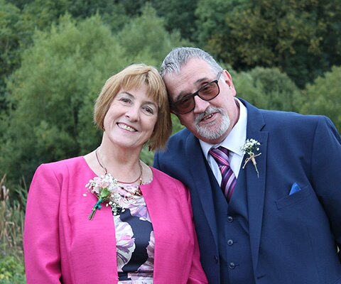 Adult with cochlear implant poses with his wife
