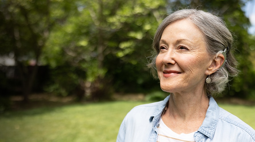 A smiling family sit around a dinner table, posing for a family photo