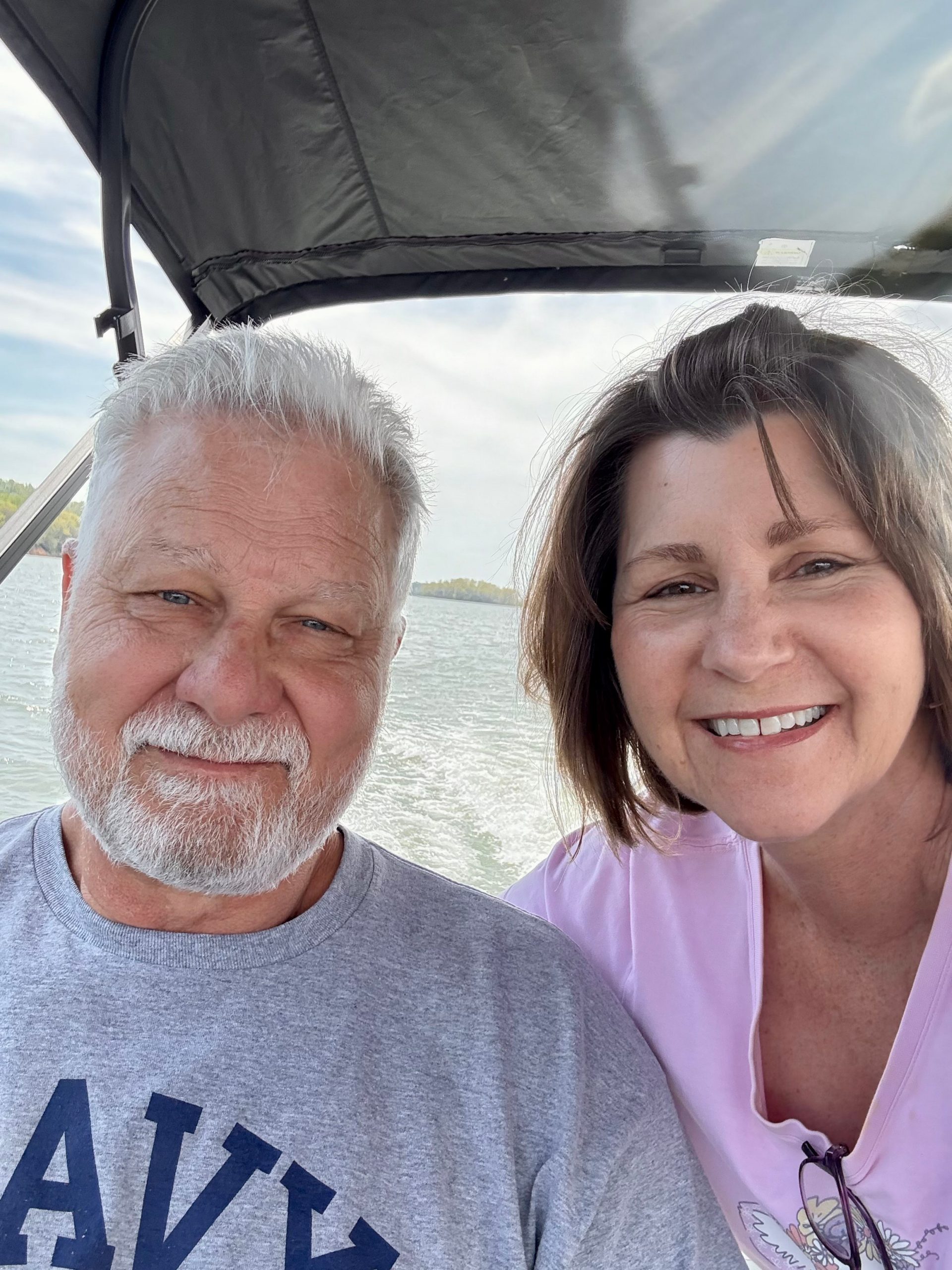 blog author Joan and a man smiling on a boat, enjoying life after hearing loss intervention