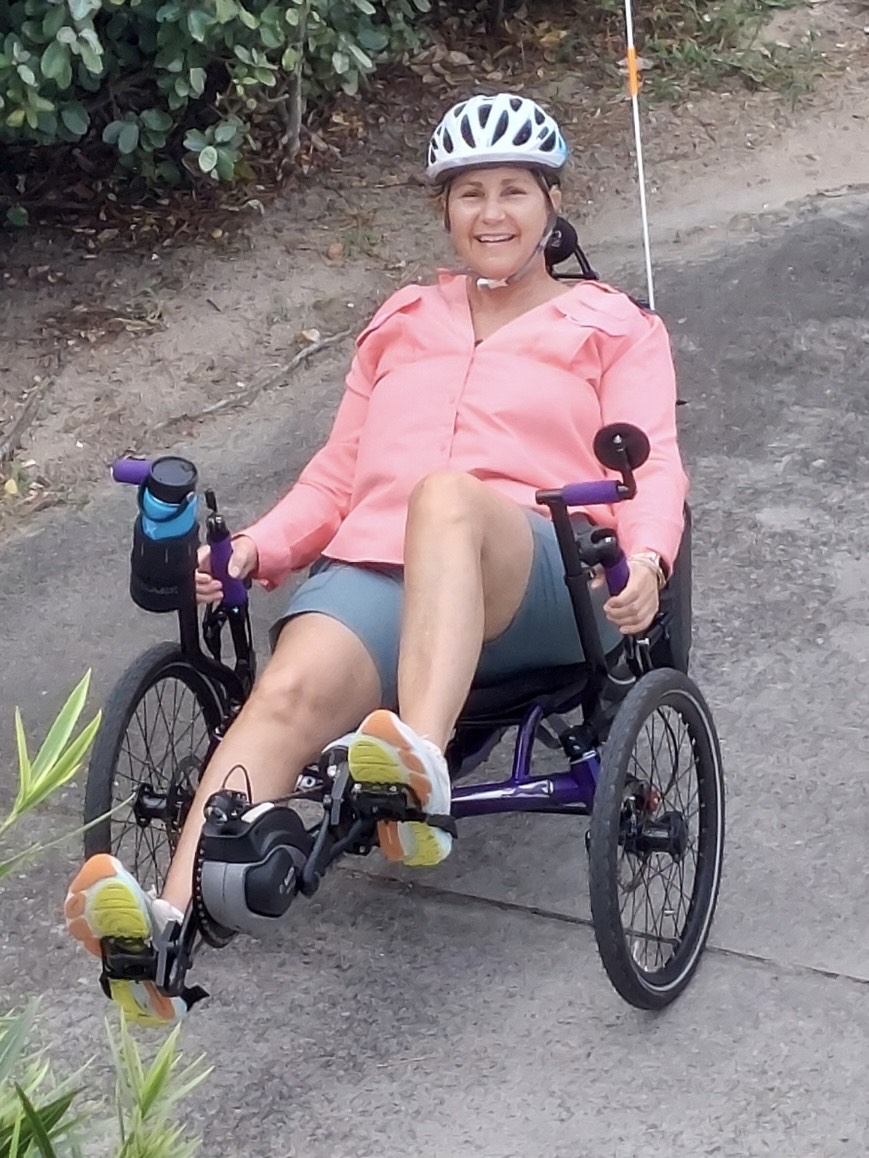 Joan exercising on a low-seated bike, staying active after hearing loss intervention