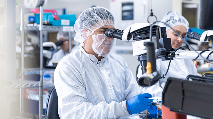 A medical professional uses a microscope