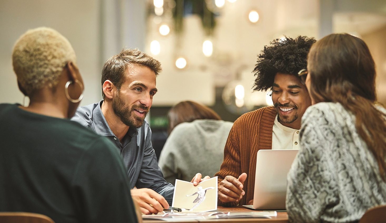 Diverse group of business professionals holding a meeting at desk.